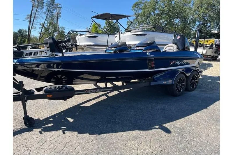 Slide: The Image of 2024 Vexus VX20 boat on trailer, parked outdoors, surrounded by trees and other boats. - 4