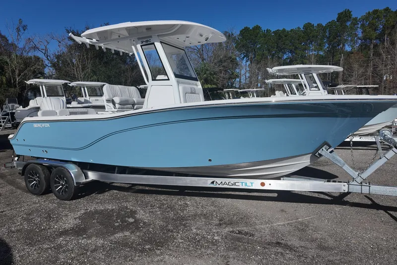 The Image of Blue Sea Fox boat on a Magic Tilt trailer, parked outdoors. - 0