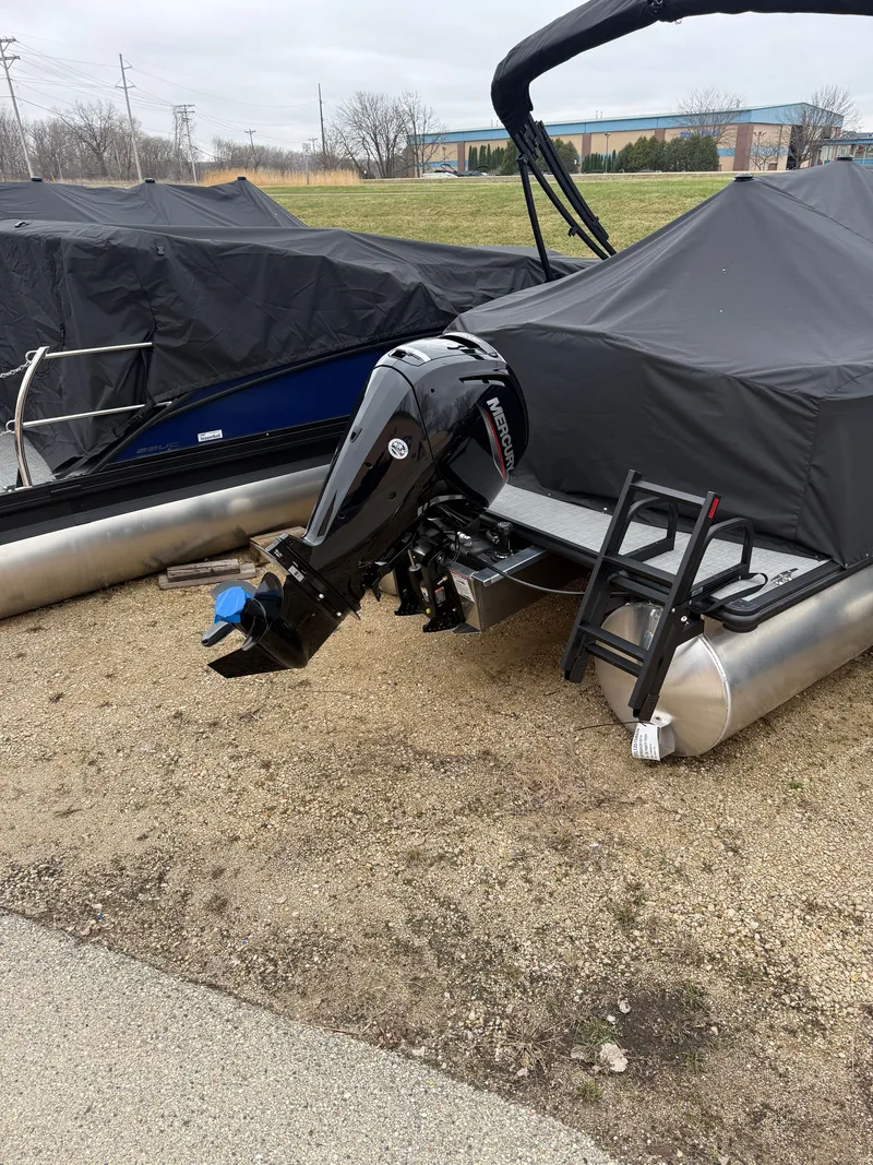 Slide: The Image of 2026 Sylvan R-20 PARTY FISH pontoon boat with Mercury engine, covered on land. - 16