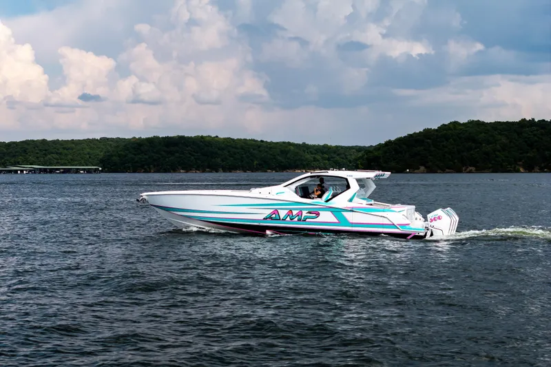 Slide: The Image of A sleek 2025 AMP 443 speedboat cruising on a scenic lake under a cloudy sky. - 10