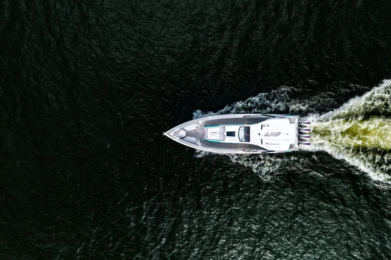 Slide: The Image of Aerial view of AMP 443 speedboat cruising on dark water, 2025 model. - 11