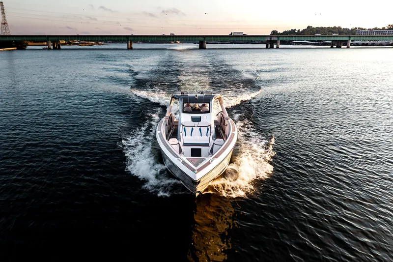 Slide: The Image of Modern AMP 443 boat cruising on a serene river at sunset, 2025 model. - 13