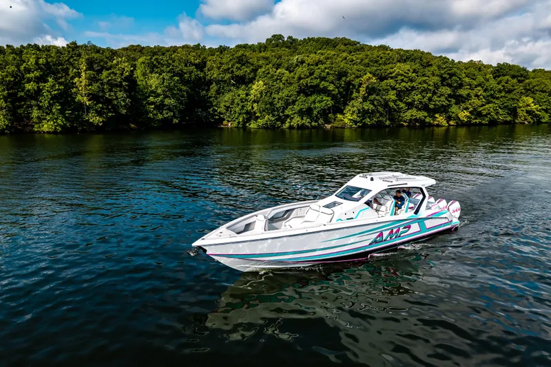 Slide: The Image of 2025 AMP 443 boat cruising on a serene lake with lush green forest backdrop. - 27