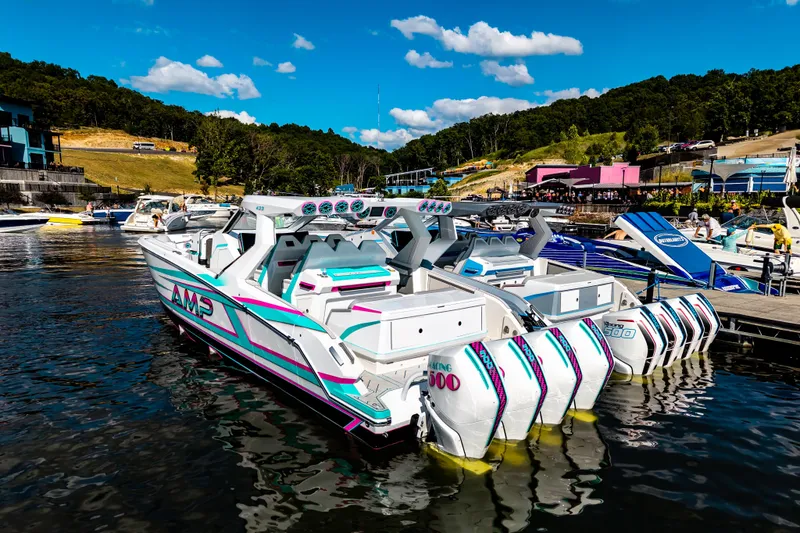 Slide: The Image of Futuristic AMP 443 speedboat docked, featuring multiple engines, vibrant design, and scenic waterfront backdrop. - 44