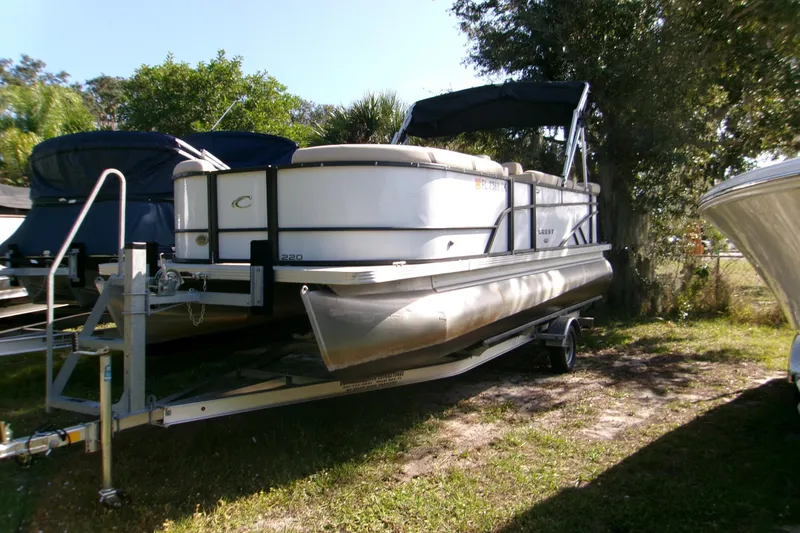 The Image of 2023 Crest Classic DLX 220 L pontoon boat on trailer, parked outdoors. - 1