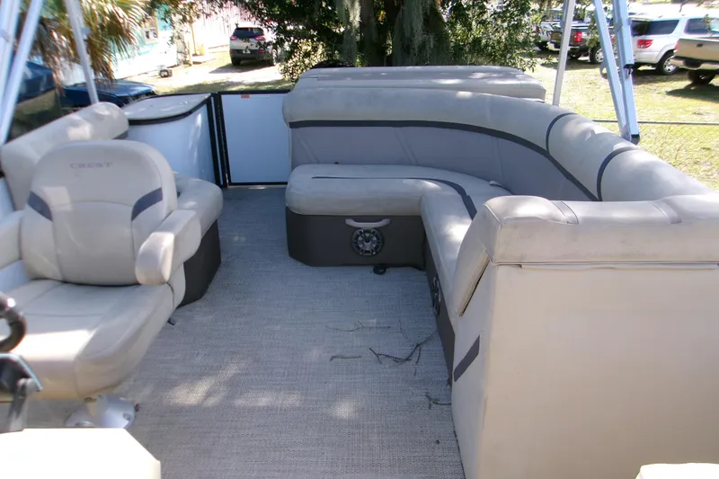 Slide: The Image of 2023 Crest Classic DLX 220 L pontoon boat interior with beige seating. - 3