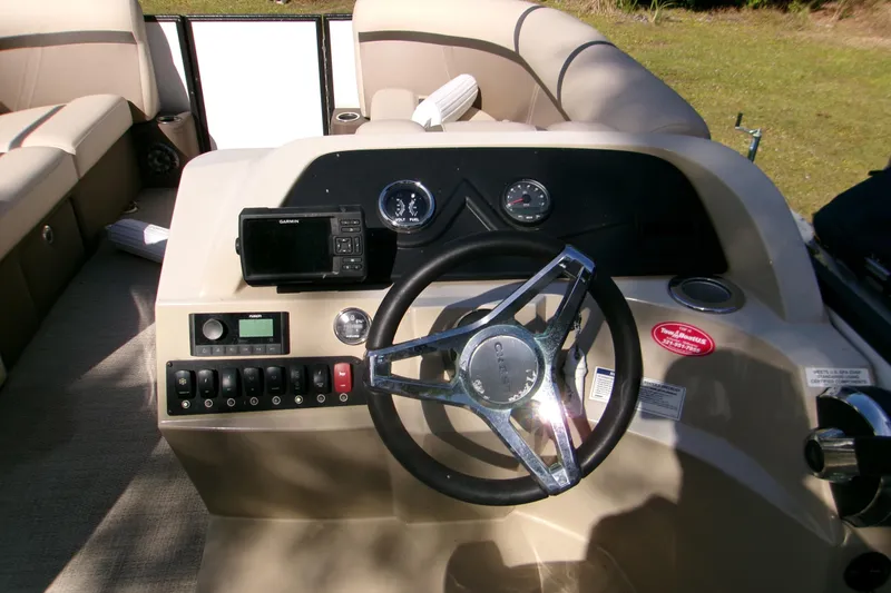 Slide: The Image of 2023 Crest Classic DLX 220 L boat dashboard with steering wheel and controls. - 8