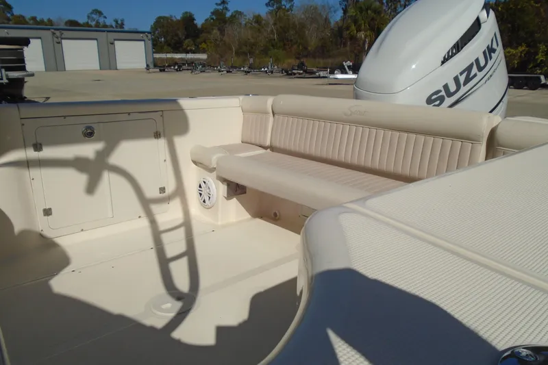 Slide: The Image of 2004 Scout 242 Abaco boat interior with Suzuki outboard motor, featuring beige seating. - 10