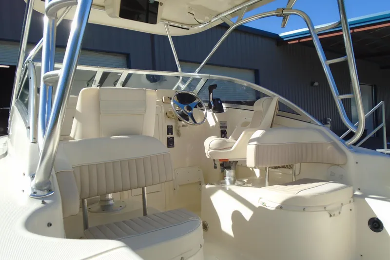 Slide: The Image of 2004 Scout 242 Abaco boat interior with steering wheel and seating. - 11