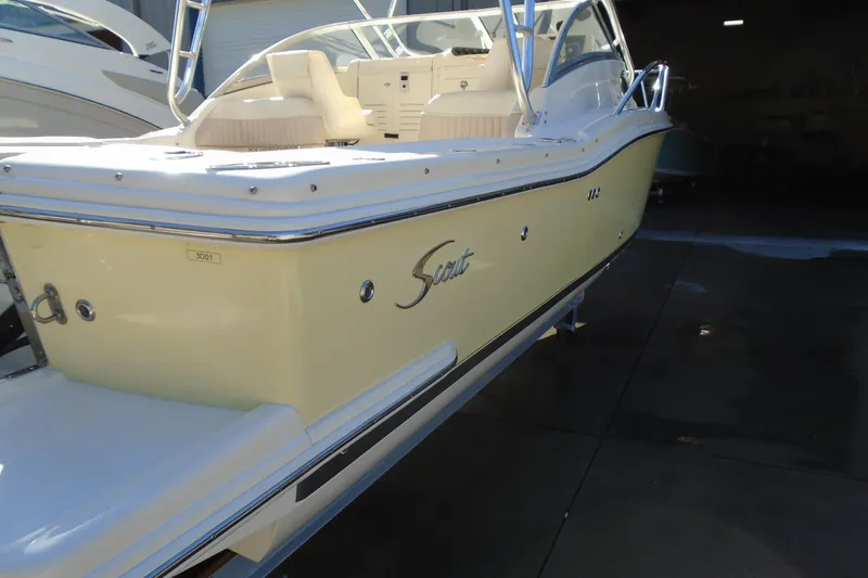 Slide: The Image of 2004 Scout 242 Abaco boat in a showroom, featuring sleek design and cream color. - 14
