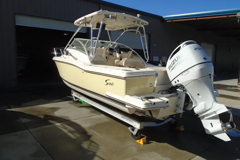 Slide: The Image of 2004 Scout 242 Abaco boat with Suzuki outboard motor in a garage setting. - 2