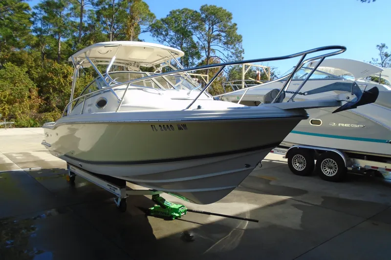 Slide: The Image of 2004 Scout 242 Abaco boat on trailer, parked outdoors with trees in background. - 6