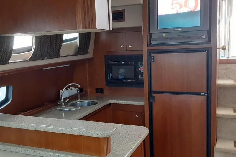 Slide: The Image of 2003 Cruisers Yachts 4050 Express interior with kitchen, microwave, and TV. - 17