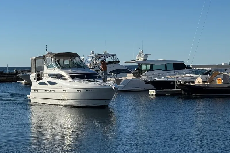 Slide: The Image of 2003 Cruisers Yachts 4050 Express in marina, surrounded by other boats, under clear blue sky. - 1