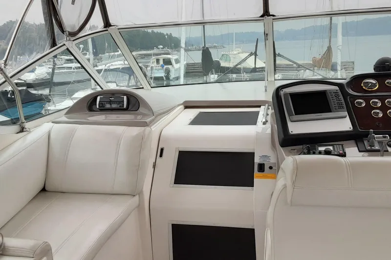 Slide: The Image of 2003 Cruisers Yachts 4050 Express cockpit with white seating and navigation controls. - 11