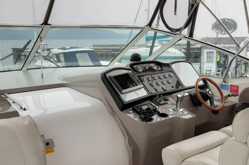 Slide: The Image of 2003 Cruisers Yachts 4050 Express helm with steering wheel and control panel. - 12
