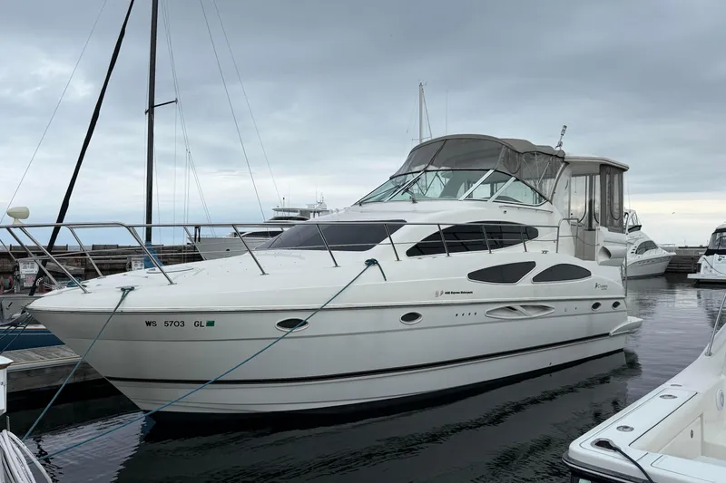 Slide: The Image of 2003 Cruisers Yachts 4050 Express docked at marina under cloudy sky. - 2