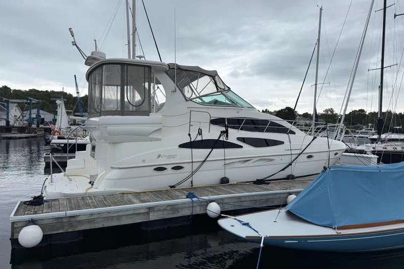 Slide: The Image of 2003 Cruisers Yachts 4050 Express docked at marina under cloudy sky. - 5