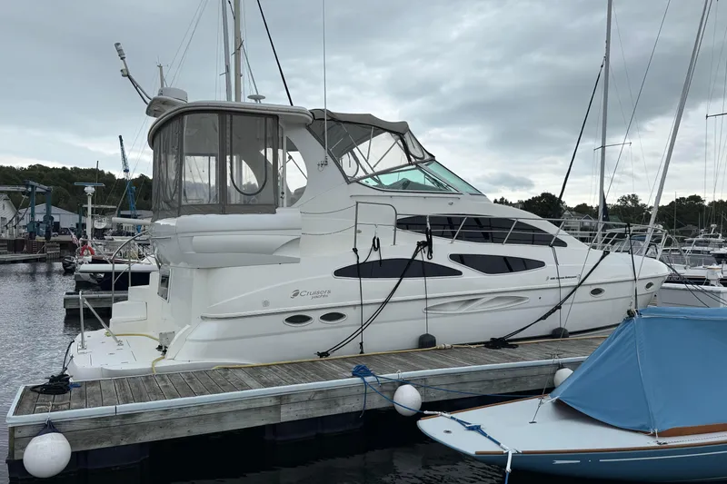 Slide: The Image of 2003 Cruisers Yachts 4050 Express docked at marina under cloudy sky. - 6