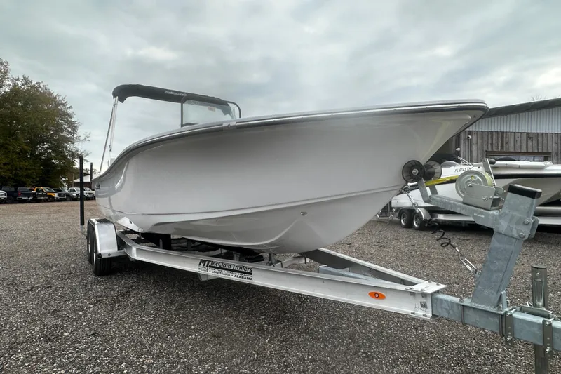 Slide: The Image of 2026 Action Craft 22 Bay boat on trailer, parked outdoors under cloudy sky. - 12