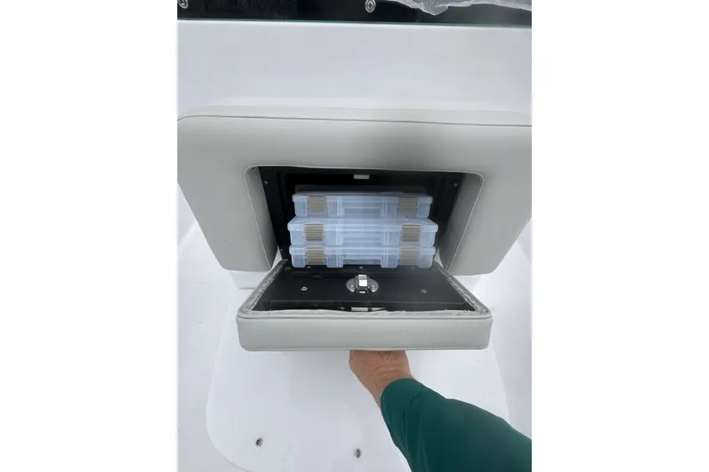 Slide: The Image of 2026 Action Craft 22 Bay boat storage compartment with tackle boxes. - 23