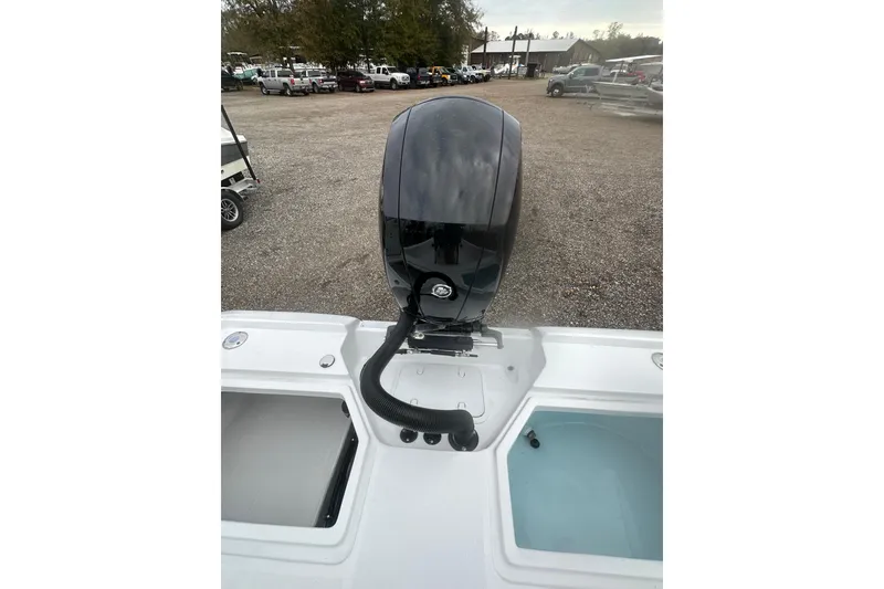 Slide: The Image of 2026 Action Craft 22 Bay boat with a powerful outboard motor in a parking lot. - 32