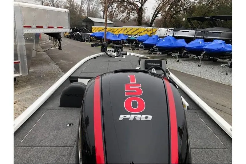 Slide: The Image of 2025 Vexus AVX1980 boat with 150 Pro engine, parked near covered boats. - 4