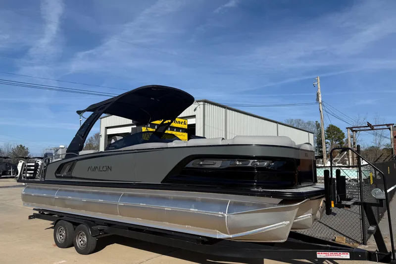 The Image of 2026 Avalon Excalibur LTD Quad Lounge Windshield pontoon boat on trailer, outdoor display. - 0
