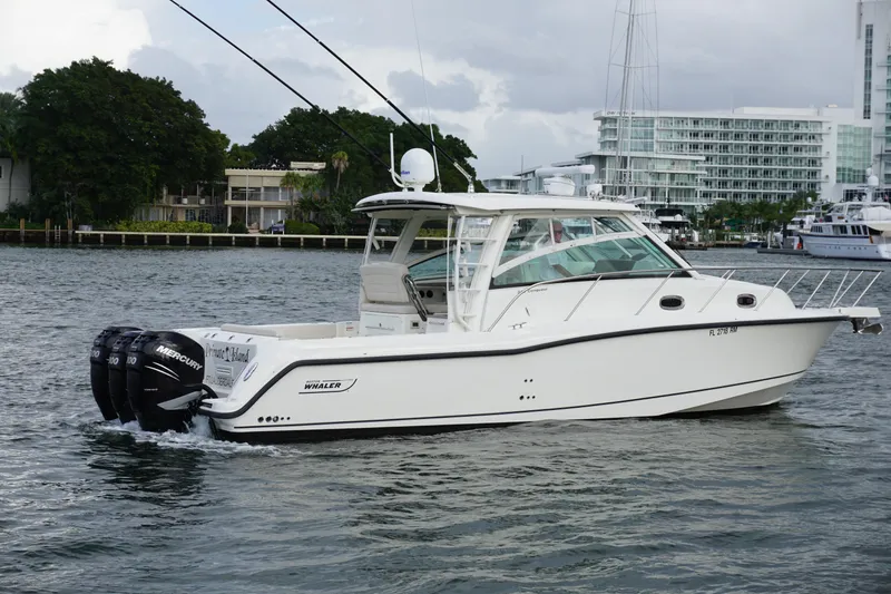 Slide: The Image of 2015 Boston Whaler 345 Conquest cruising on blue ocean near city skyline. - 11