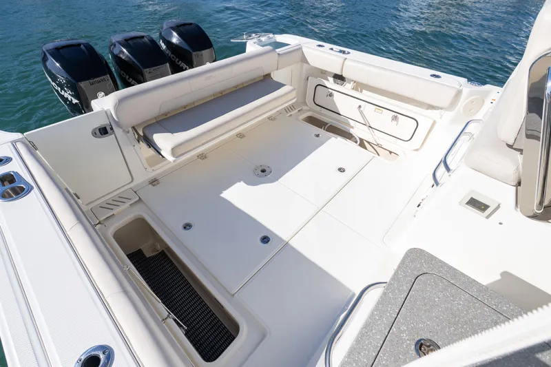 Slide: The Image of 2015 Boston Whaler 345 Conquest boat deck with seating and storage, featuring triple outboard engines. - 32