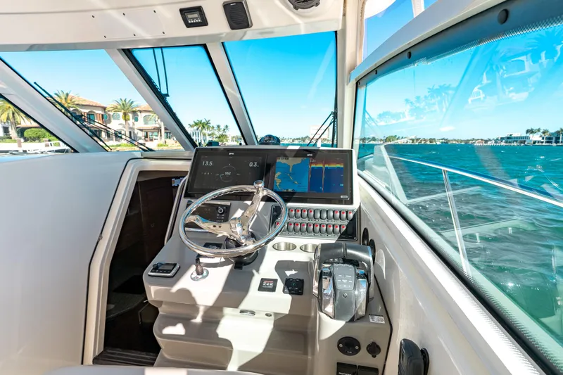 Slide: The Image of Helm of 2015 Boston Whaler 345 Conquest with navigation screens and ocean view. - 49
