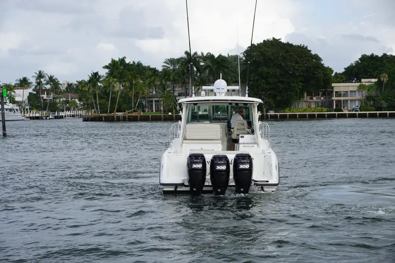 Slide: The Image of 2015 Boston Whaler 345 Conquest with triple outboard engines on water. - 8