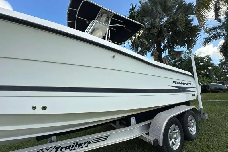 Slide: The Image of 2003 Hydra-Sports Vector 2400 CC boat on trailer, parked near palm trees. - 10