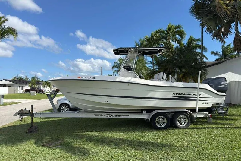 Slide: The Image of 2003 Hydra-Sports Vector 2400 CC boat on trailer, parked in a grassy area. - 13