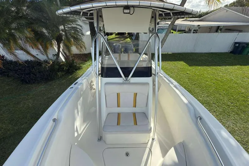 Slide: The Image of 2003 Hydra-Sports Vector 2400 CC boat with T-top and seating, parked on grass. - 19