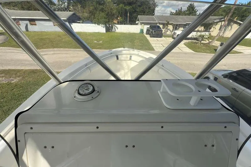 Slide: The Image of 2003 Hydra-Sports Vector 2400 CC boat console with cup holders and compass, parked in a residential area. - 23