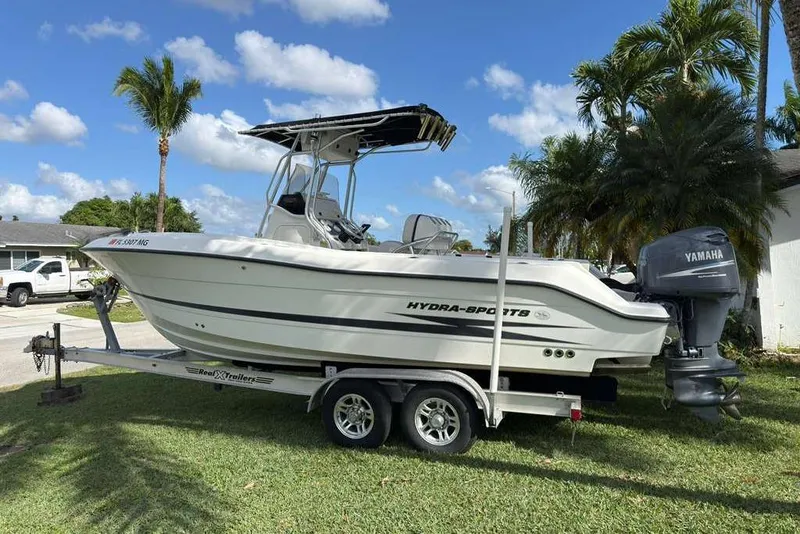 Slide: The Image of 2003 Hydra-Sports Vector 2400 CC boat on trailer, parked on grass with palm trees. - 8