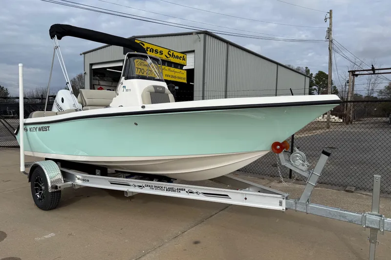 The Image of 2026 Key West 189 FS boat on trailer, parked outside a warehouse. - 0