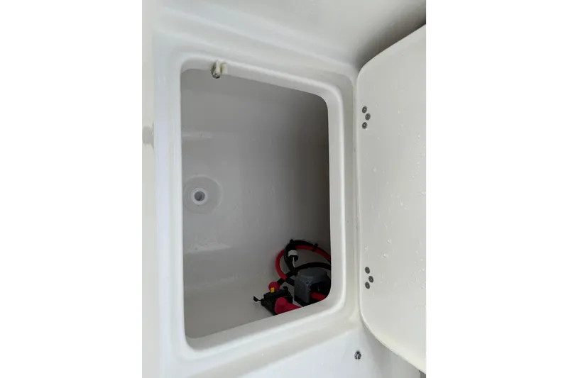 Slide: The Image of Storage compartment in 2026 Key West 189 FS boat, featuring interior wiring and drainage. - 23