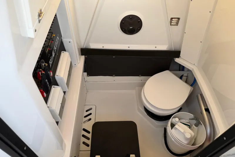 Slide: The Image of Interior of 2023 Blackfin 272 CC boat featuring a compact marine toilet. - 11
