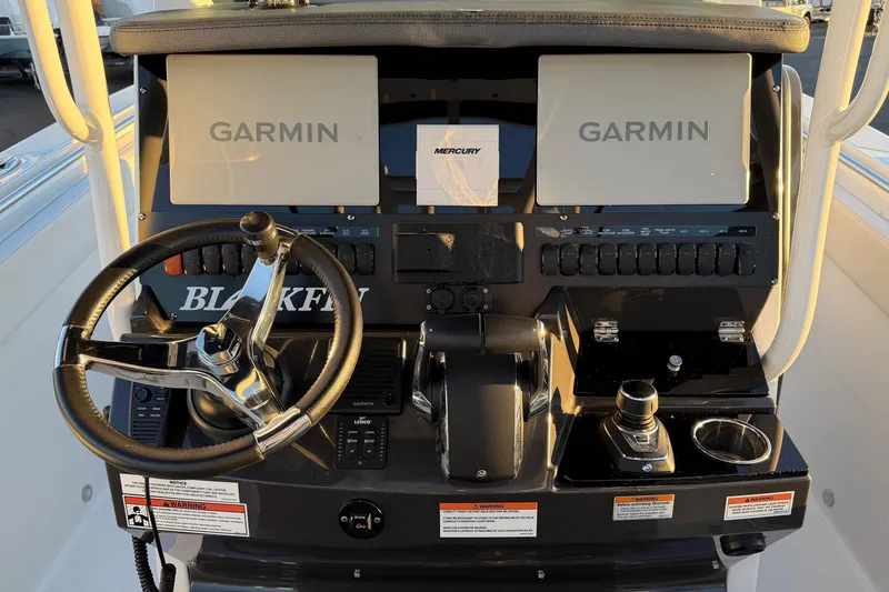Slide: The Image of 2023 Blackfin 272 CC boat dashboard with Garmin displays and Mercury controls. - 12