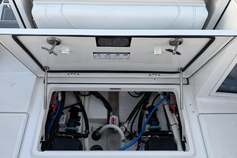 Slide: The Image of 2023 Blackfin 272 CC boat compartment with open hatch, showcasing internal wiring and components. - 24