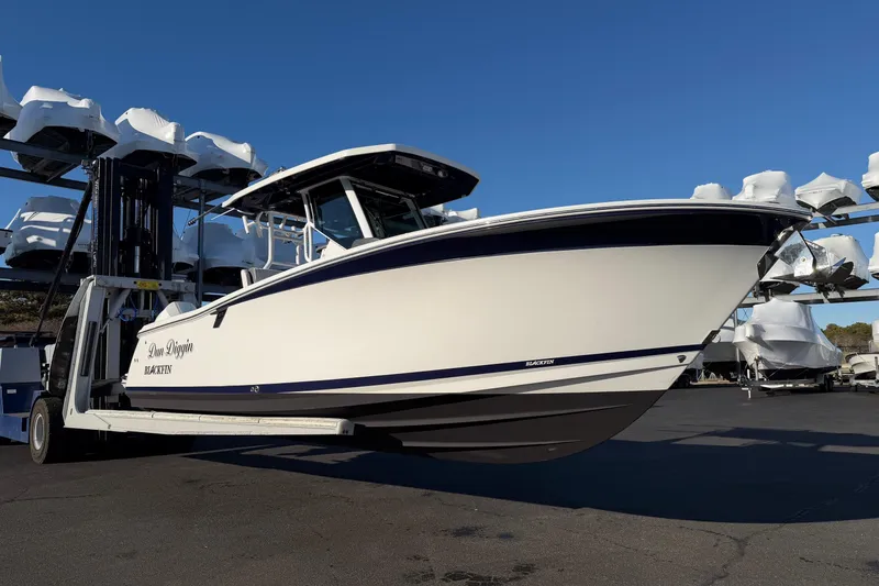 Slide: The Image of 2023 Blackfin 272 CC boat on a lift, surrounded by other boats. - 3