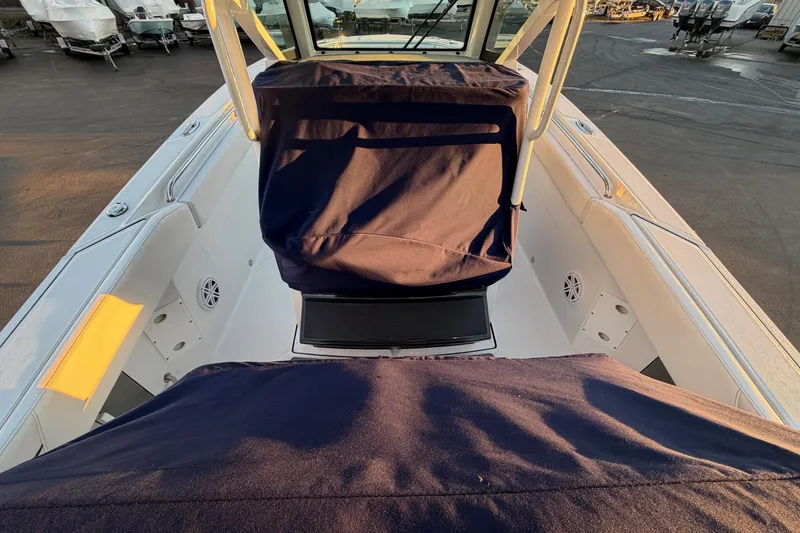 Slide: The Image of 2023 Blackfin 272 CC boat interior with navy covers, docked in a marina. - 33