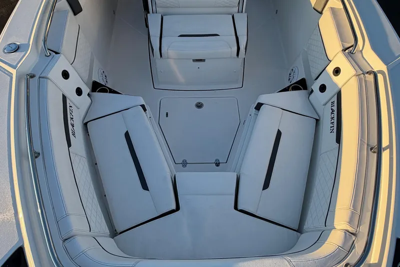 Slide: The Image of 2023 Blackfin 272 CC boat interior with white cushioned seating and storage compartments. - 7