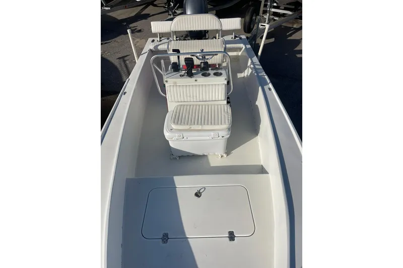Slide: The Image of 1974 Mako 1701 Inshore boat interior with white seating and control console. - 10