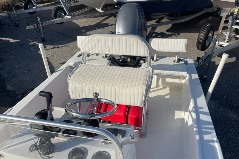 Slide: The Image of 1974 Mako 1701 Inshore boat interior with white seating and steering wheel. - 11