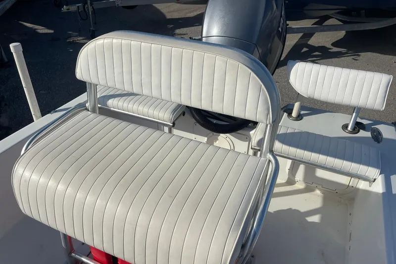 Slide: The Image of 1974 Mako 1701 Inshore boat with white cushioned seating and steering wheel. - 13