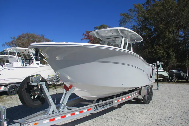 Slide: The Image of 2026 Sea Fox 288 Commander boat on trailer, parked outdoors under clear blue sky. - 1