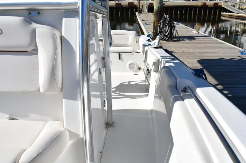 Slide: The Image of 2018 Sea Hunt Ultra 225 boat interior with white seating and dockside view. - 17